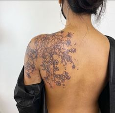 the back of a woman's shoulder with flowers on it