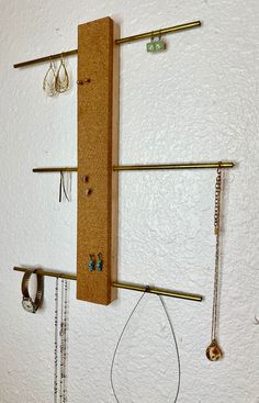 a wall mounted jewelry rack with earrings hanging on it