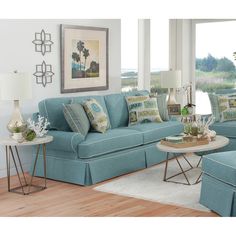 a living room with blue couches and white rugs on the wooden flooring