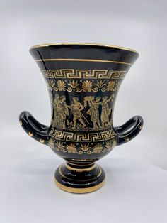 a black and gold vase sitting on top of a table