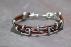 "Simple, cool, rugged...that's this bracelet. Made of a soft yet sturdy distressed leather, and featuring hammered silver beads, with a unique silver \"s\" hook which swivels for easy on/off. This bracelet is available in the 4 sizes indicated; if you need a different size than shown, or the size you need is showing as sold out, please message me prior to purchase so I can ensure the timeframe for delivery in your size. First photo shows leather color #3. Also available in other leather colors, Knot Leather Bracelet, Barrel Knot, Handmade Leather Jewelry, Leather Jewelry Diy, Womens Cuff Bracelets, Handmade Leather Bracelets, S Hook, Beaded Wrap Bracelets, Leather Cuffs Bracelet