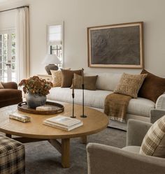 a living room with couches, chairs and a coffee table in front of a window