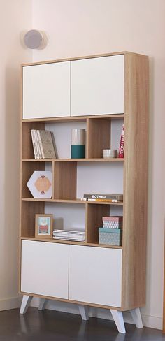 a white and wood book shelf with books on it's sides in a room