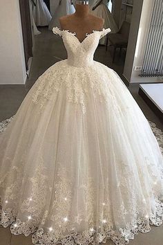 a white wedding dress on display in front of a mirror