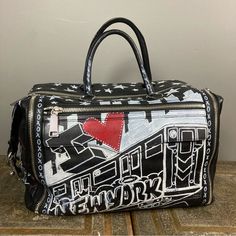 Rebecca Minkoff Luggage Duffle Leather Bag Graffiti Runway Ny Fashion Week 2022 Men's Or Women's This Bag Made Its Debut At Ny Fashion Week For 2022-2023 Spring And Summer! It Is Brand New Never Carried And Is Likely A One Of A Kind, Limited Edition! This Was Created Just For The Show. It Was Hand Painted With All Kinds Of Iconic Nyc References And Lyrics From Frank Sinatra Spelled Out Plus: - The Subway - "I (Heart) New York" - Rebecca's Initials - "The Big Apple" - "Fearless" - Stars As Part O Designer Leather Duffle Bag For Shopping, Designer Black Weekender Bag For Daily Use, Designer Duffle Bag For Shopping, Designer Rectangular Duffle Bag With Zipper Closure, Designer Weekender Bag For Everyday Use, Designer Black Weekender Bag, Designer Weekender Bag, Designer Satchel Weekender Bag, Designer Black Duffle Bag With Luggage Sleeve