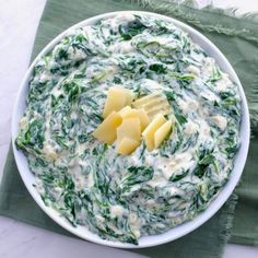 a white bowl filled with spinach and cheese