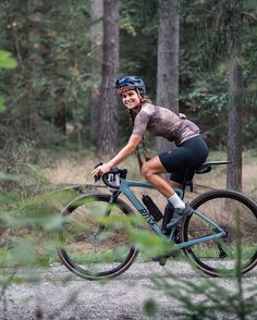 a woman is riding her bike through the woods