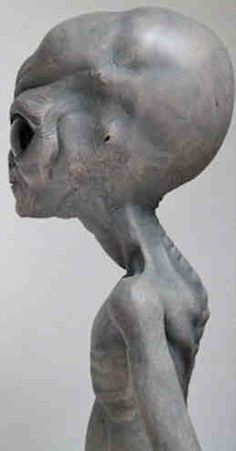 an alien statue is shown with its head in the air and it's eyes closed