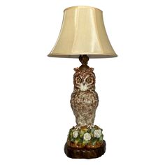 an owl lamp sitting on top of a table next to a beige shade light fixture