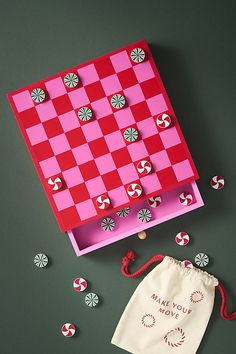 a pink and red checkerboard board next to some candy canes on a table