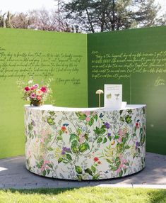 a flower pot sitting on top of a table next to a wall with writing in it