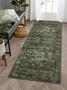 a green rug in a living room next to a chair and potted plant on the floor