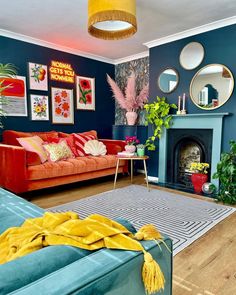 a living room filled with furniture and a fire place in front of a blue wall