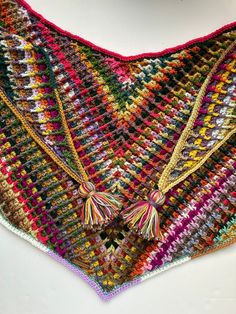 a multicolored crocheted shawl with tassels