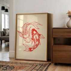 a red and white painting sitting on top of a wooden floor next to a dresser