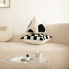 a white couch with black and white pillows on it