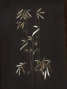 three tall bamboo trees lit up in the dark