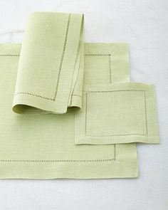 the linen is light green and has stitched edges on each side, along with two matching napkins