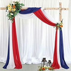 a red, white and blue wedding arch decorated with flowers