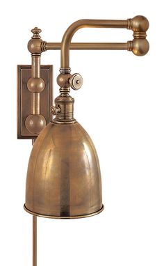 an old fashioned wall light with a metal shade on the arm and two brass fittings