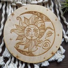 the sun and moon is carved on wood with tassels hanging from it's sides