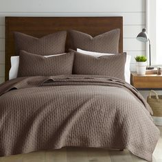 a bed with brown bedspread and pillows