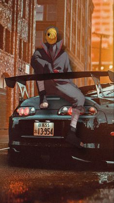 a person sitting on top of a car in the street