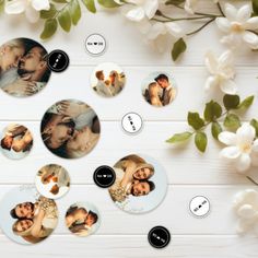 a bunch of buttons that are sitting on a white table next to some flowers and leaves