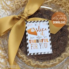 there is a card on top of a cookie in a glass bowl with a yellow ribbon around it