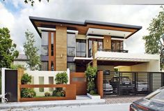 a car is parked in front of a modern house with wood and white trimmings