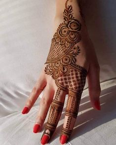 a woman's hand painted with henna on top of a white bed sheet