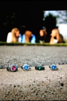 five rings sitting on the ground in front of some other people and one is laying down