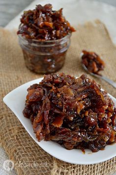 a white plate topped with raisins next to a bowl of raisins