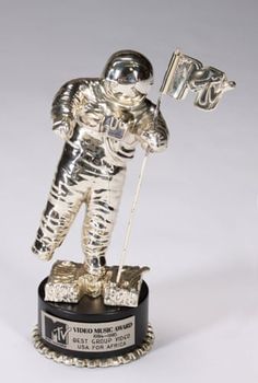 an astronaut statue holding a flag on top of a black base