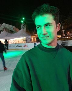 a man standing in front of a skating rink at night