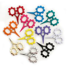 several pairs of scissors sitting next to each other on a white surface with one pair cut out