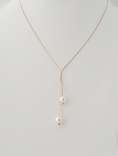 Golden lariat necklace, minimalist and classic pearl necklace.  Choose from off white or white pearls for your necklace.   Two top quality 8mm crystal pearls hang from a gold plated snake chain. Classic every day necklace. When choosing the length, this does not include the pearl dangles.  The length is just the length of the chain.  The dangles measure 2in and 1in.  Please consider this when ordering your size.  If you are unsure, then please ask. Your jewellery will arrive in a gift box ready for giving. White Pearl Lariat Necklace With Clavicle Chain, Pearl White Pearl Lariat Necklace, Elegant Pearl White Lariat Necklace, Elegant Adjustable Lariat Necklace With Pearl Charm, Minimalist Pearl Lariat Necklace, Formal Adjustable Lariat Necklace With Pearl Drop, Dainty White Lariat Necklace With Pearl Charm, Minimalist White Lariat Pearl Necklace, Minimalist Pearl Drop Backdrop Necklace