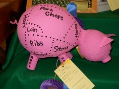 a pink piggy bank sitting on top of a green tablecloth covered table cloth