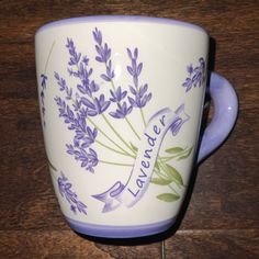 a purple and white coffee cup sitting on top of a wooden table