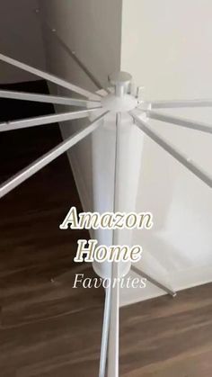 an umbrella that has the words amazon home on it in front of a wall with wood flooring