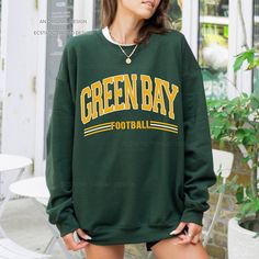 "Get ready for Green Bay football with this vintage-style, varsity sweatshirt. This crewneck has a retro design for your game day.  - These are Unisex fit. Please check sizing if you would like to order up 1-2 sizes for an oversized sweatshirt. * Packaged and Shipped in the USA! ---UNISEX SWEATSHIRTS--- - Specially spun cotton/poly, 50/50 - Medium-heavy soft fabric - Classic fit - Tear-away label - Runs true to size ---SIZES--- Small - 20\" W | 27\" L Medium - 22\" W | 28\" L Large - 24\" W | 29\" L XLarge - 26\" W | 30\" L 2XLarge - 28\" W | 31\" L 3XLarge - 30\" W | 32\" L 4XLarge - 32\" W | 33\" L ---CARE INSTRUCTIONS--- - Wash clothing inside out on cold setting - Tumble dry: low heat setting - Do not use bleach - Do not dry clean - Do not iron directly on design - Colors may look slig Oversized Tops For School Spirit In Fall, Oversized Tops For Fall With School Spirit, Long Sleeve Top With Team Name For Fall, College Style Long Sleeve Tops For Sports Season, Fall Long Sleeve College Style T-shirt, School Spirit Long Sleeve T-shirt For Fall, Long Sleeve School Spirit T-shirt For Fall, Long Sleeve T-shirt For School Spirit In Fall, Long Sleeve College Style T-shirt For Fall