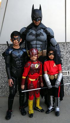 a group of kids dressed up as batman and robin wayne standing next to each other