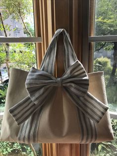 a bag hanging from the side of a window sill with a bow on it