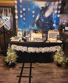 a train themed dessert table with christmas decorations and lights on the tables are set up in front of a backdrop