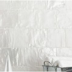 a white brick wall next to a towel rack