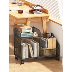 a metal basket with books and magazines on it next to a wooden table in front of a window