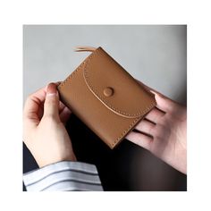 a person holding a brown wallet in their hand