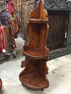 a wooden shelf sitting on top of a floor in front of a store display case