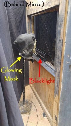 an image of a black mask hanging from the side of a window with words below it