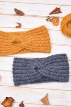 three crocheted headbands laying next to each other on a wooden surface